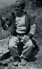 HAB21: “Highland attire. Typical are long, tight-fitting, white woollen trousers with black braiding. The opankas [shoes] are made of old car tires” (Photo: Hugo Bernatzik, 1929).