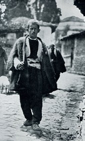 HAB43: “Peasant in Berat. The streets are covered in Turkish cobblestone and at the side flows stinking sewage” (Photo: Hugo Bernatzik, 1929).