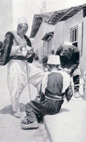 FW048A: “Delicious ice cream! The black sash is said to be a traditional sign of mourning for the death of Scanderbeg” (Photo: Friedrich Wallisch, 1931).